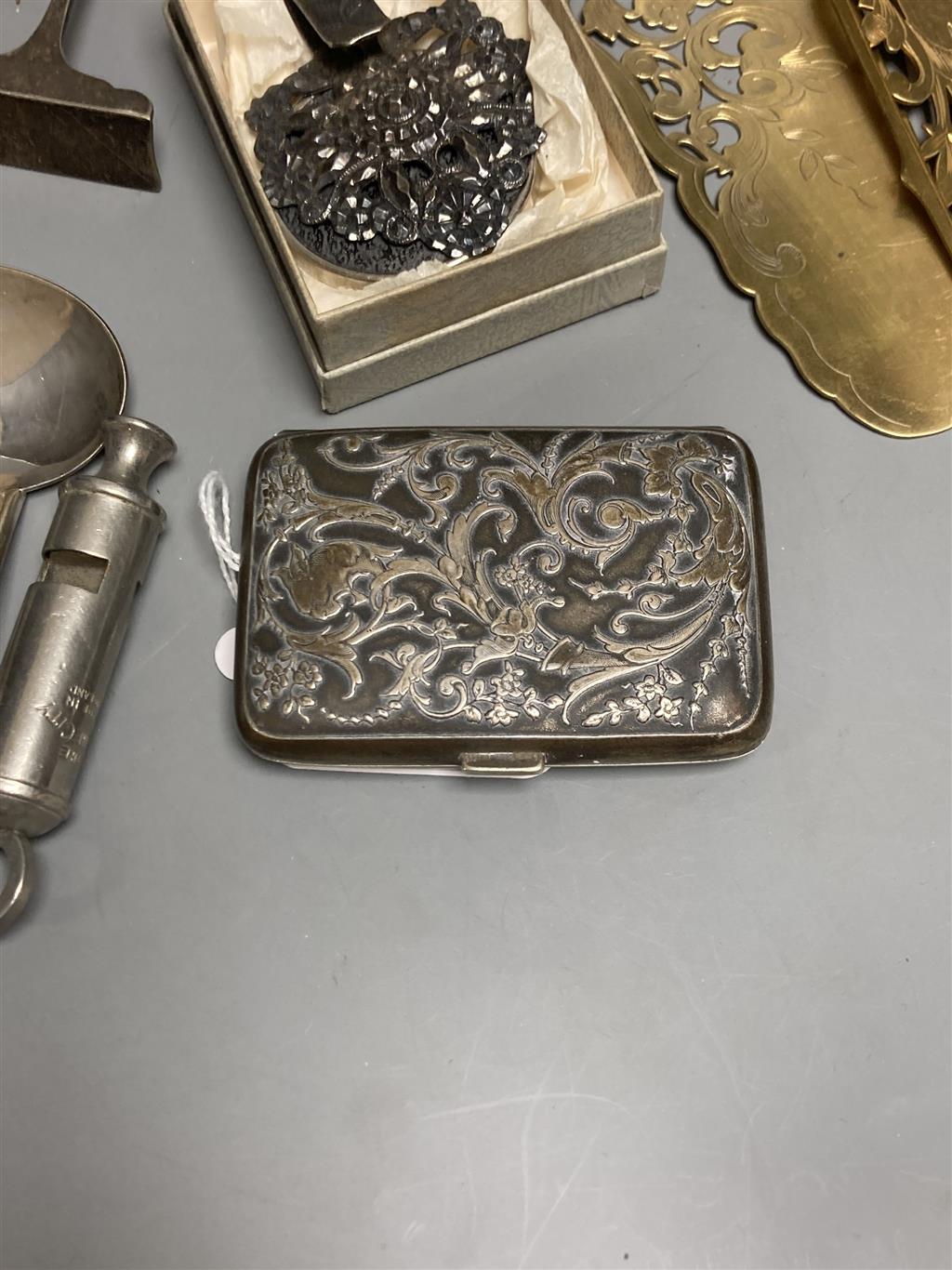 Two plated whistles, Acme and Metropolitan, a white metal embossed cigarette case and sundry items,